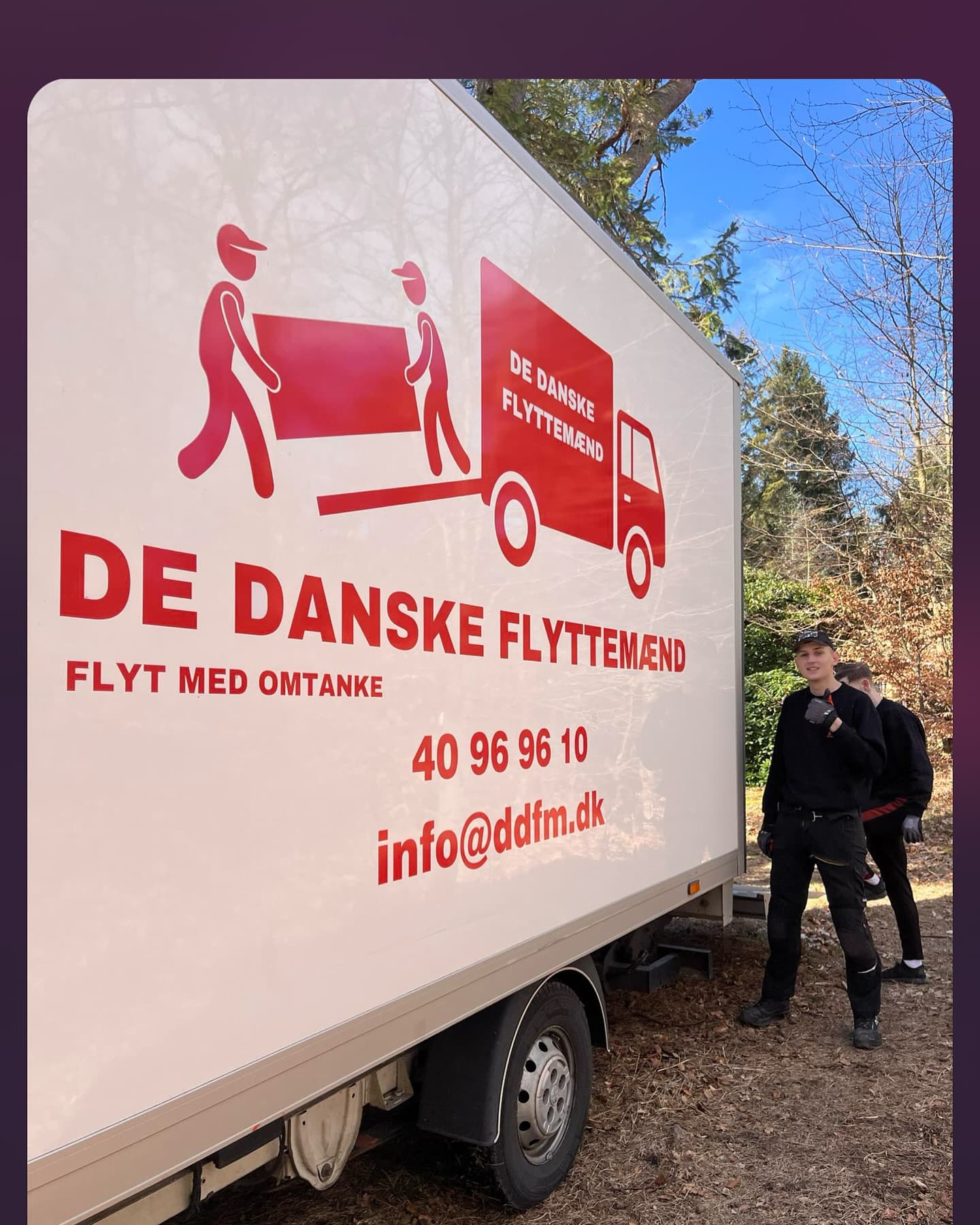 To flyttemænd står ved siden af den hvide flyttebil.